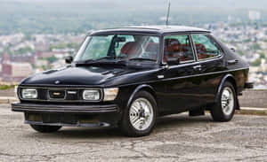 Caption: Stunning Vintage Saab 99 Turbo In Nature Wallpaper