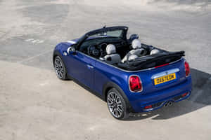 Caption: Stylish Mini Cooper Convertible Cruising Down The Street Wallpaper