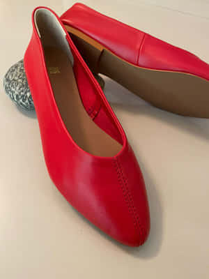 Caption: Stylish Red Shoes On A Wooden Floor Wallpaper