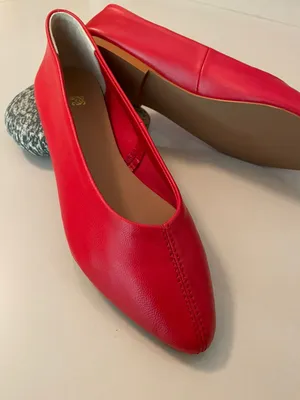 Caption: Stylish Red Shoes On A Wooden Floor Wallpaper