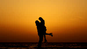 Caption: Sunset Embrace At The Seashore Wallpaper