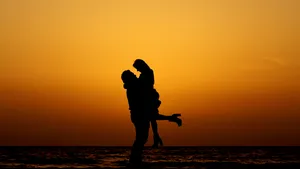 Caption: Sunset Embrace At The Seashore Wallpaper