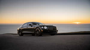 Caption: The Elegant And Powerful Bentley Flying Spur Cruising On The Open Road Wallpaper