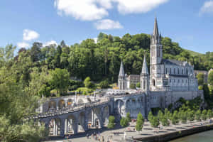 Caption: Tranquil Evening At The Lourdes Sanctuary, France Wallpaper