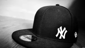 Caption: Trendy Black Ny Cap Wallpaper