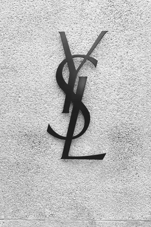 Caption: Ysl Logo Against A Black Concrete Wall Wallpaper