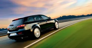 Captivating Alfa Romeo 159 Sports Sedan On A Scenic Highway Wallpaper