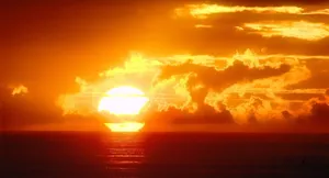 Captivating Orange Sunset Over A Serene Landscape Wallpaper