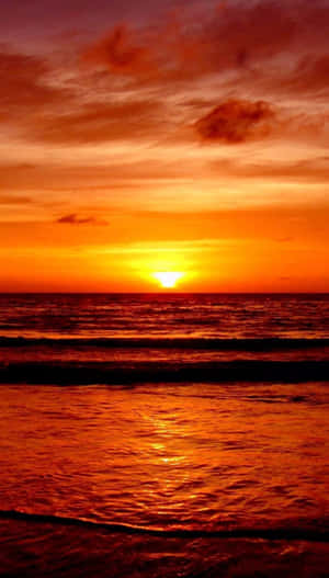 Captivating Orange Sunset Over The Ocean Wallpaper