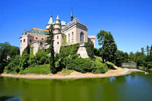 Captivating View Of Bojnice Castle Surrounded By Water Wallpaper