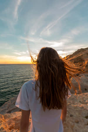 Carefree Single Woman Enjoying Freedom By The Sea Wallpaper