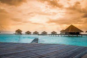 Caribbean Overwater Bungalowsat Sunset Wallpaper