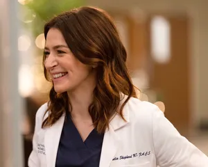 Caterina Scorsone Smilingin Doctor Coat Wallpaper