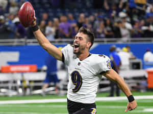 Celebratory Football Player Holding Ball Wallpaper