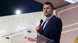 Charlie Kirk Speaking At Podium Wallpaper