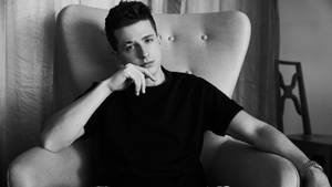 Charlie Puth Sitting Elegantly Wallpaper