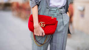 Chic Red Handbag On A Wooden Table Wallpaper