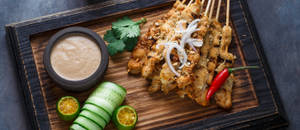 Chicken Satay On Black And Brown Wooden Tray Wallpaper