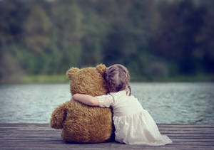 Child Hugging A Teddy Bear Wallpaper