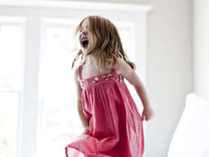 Child Jumpingon Bedin Excitement.jpg Wallpaper