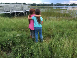 Childhood Friends Embrace Lakeside Wallpaper