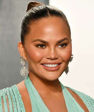 Chrissy Teigen Smiling Portraitwith Earrings Wallpaper