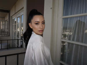 Christian Serratos Posing In Front Of A Serene Outdoor Setting Wallpaper