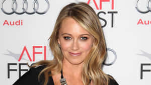 Christine Taylor Radiantly Smiling In A Casual Setting Wallpaper