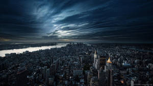 Cityscape Illuminated By Dark Clouds Wallpaper