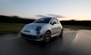 Classic Fiat 500 Cruising Down The Road Wallpaper