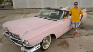 Classic Pink Cadillac In A Picturesque Setting Wallpaper