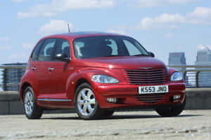 Classic Red Chrysler Pt Cruiser On Urban Road Wallpaper