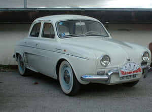 Classic Renault Dauphine Parked In Urban Setting Wallpaper