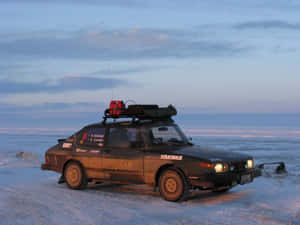 Classic Saab 900 Cruising On An Open Road Wallpaper