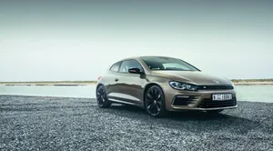 Classic Volkswagen Scirocco In Vibrant Cityscape Wallpaper