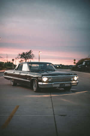 Classy Retro Car Basking In Golden Hour Wallpaper
