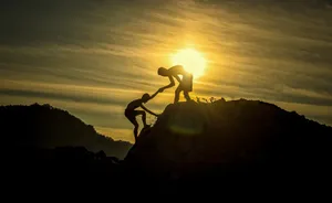 Climbers Helping During Arduous Climb Wallpaper