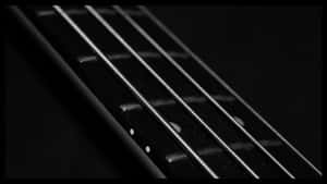 Close Up Image Of An Enticing Black Bass Guitar Wallpaper