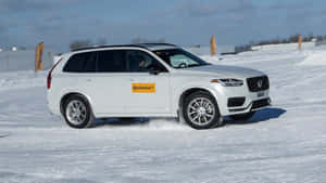 Close-up Of Winter Tires On A Snowy Road Wallpaper