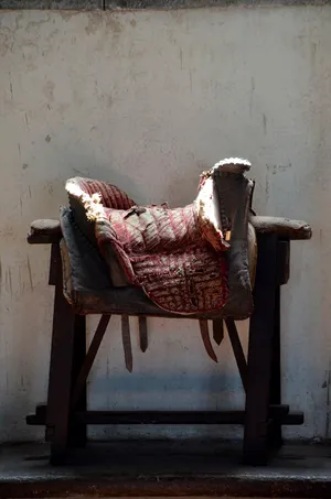 Close-up View Of A Leather Saddle On A Wooden Fence Wallpaper