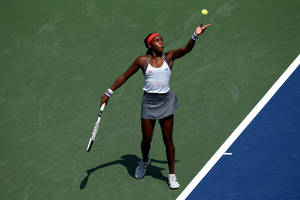 Coco Gauff Serving On Tennis Court Wallpaper