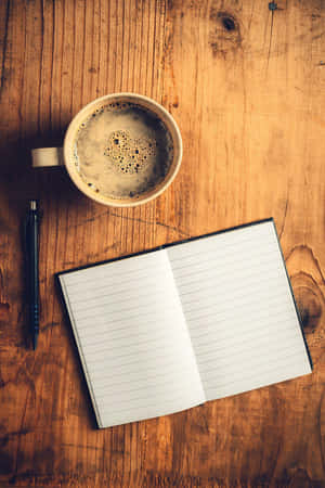 Coffeeand Notebookon Wooden Table Wallpaper