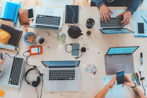 Collaborative Meeting At Laminated Office Desk Wallpaper