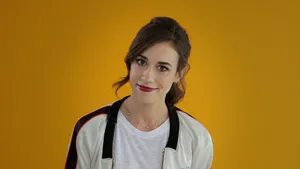 Colleen Ballinger Smiling Against Yellow Background Wallpaper