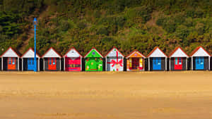 Colorful Beach Huts On The Seashore Wallpaper