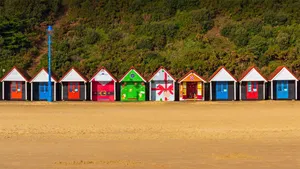 Colorful Beach Huts On The Seashore Wallpaper