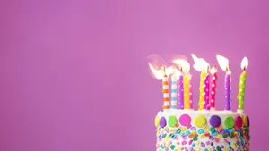 Colorful Birthday Cakewith Lit Candles Wallpaper
