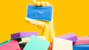 Colorful Cleaning Spongesand Gloved Hand Wallpaper