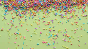 Colorful Sprinkleson Green Background Wallpaper