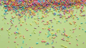 Colorful Sprinkleson Green Background Wallpaper